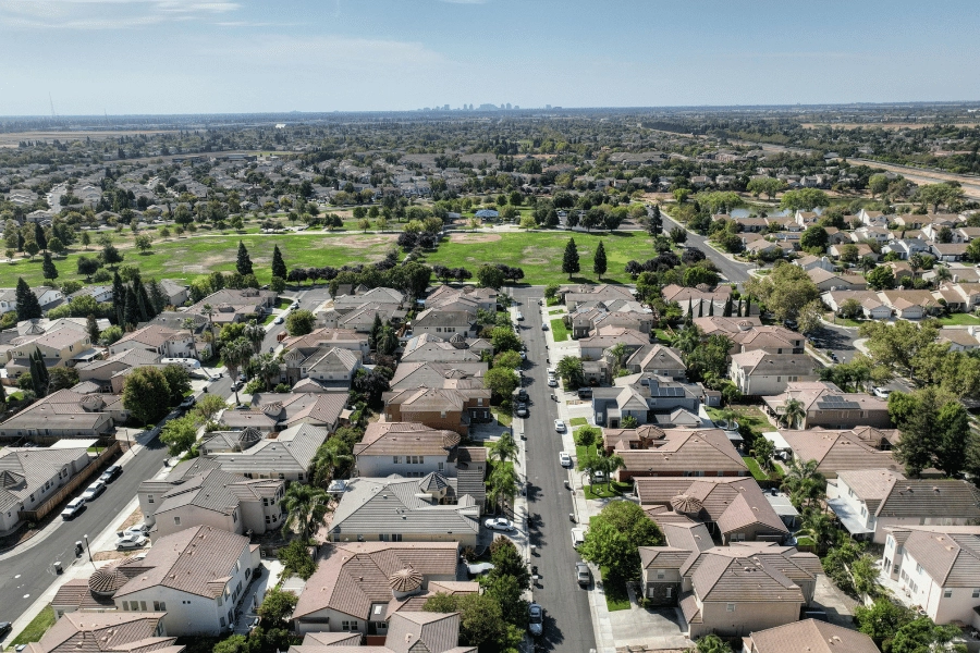 aerial view overlooking a suburban neighborhood with lots of green space